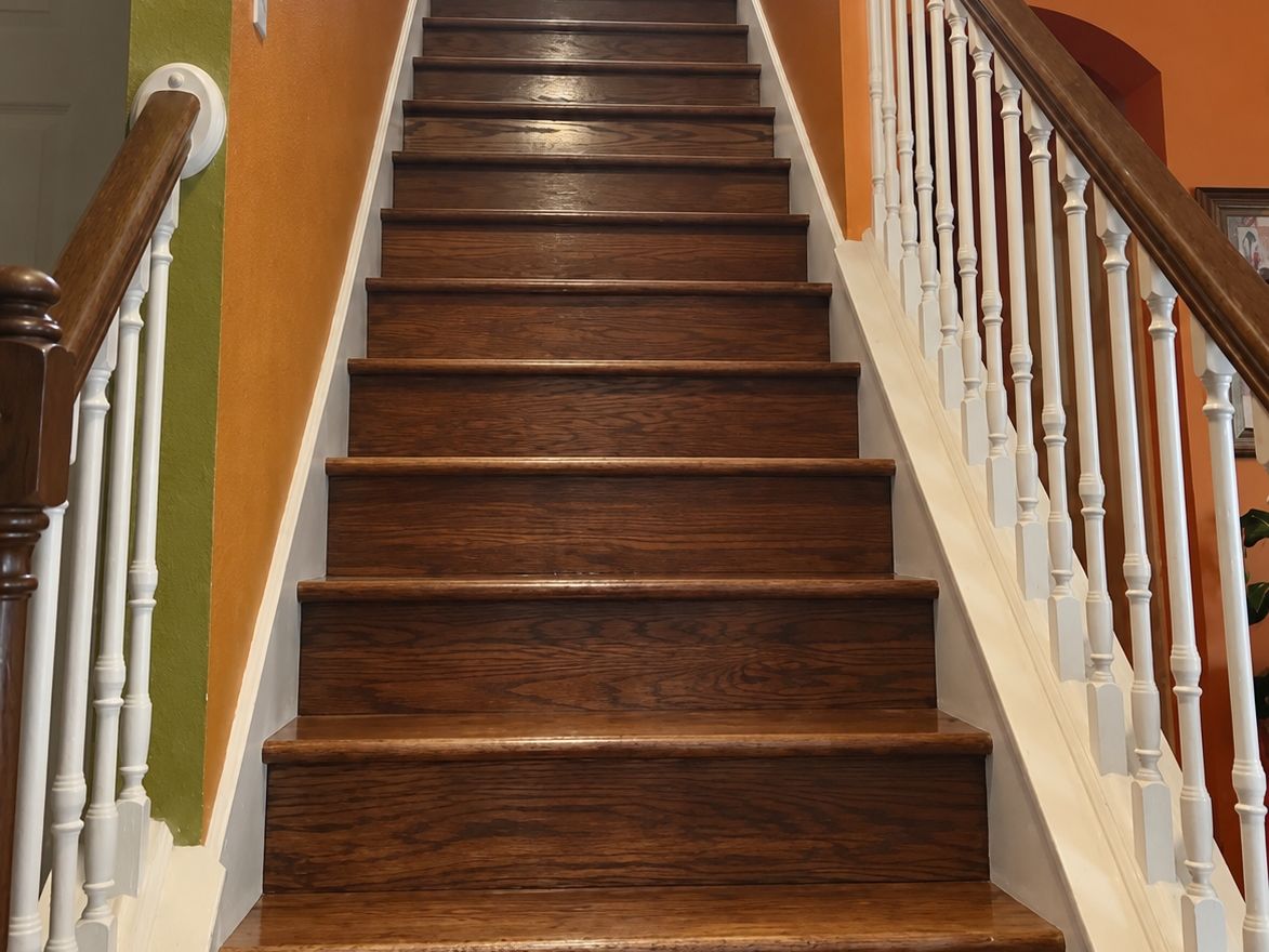 Long straight wood staircase with stained oak treads and white risers