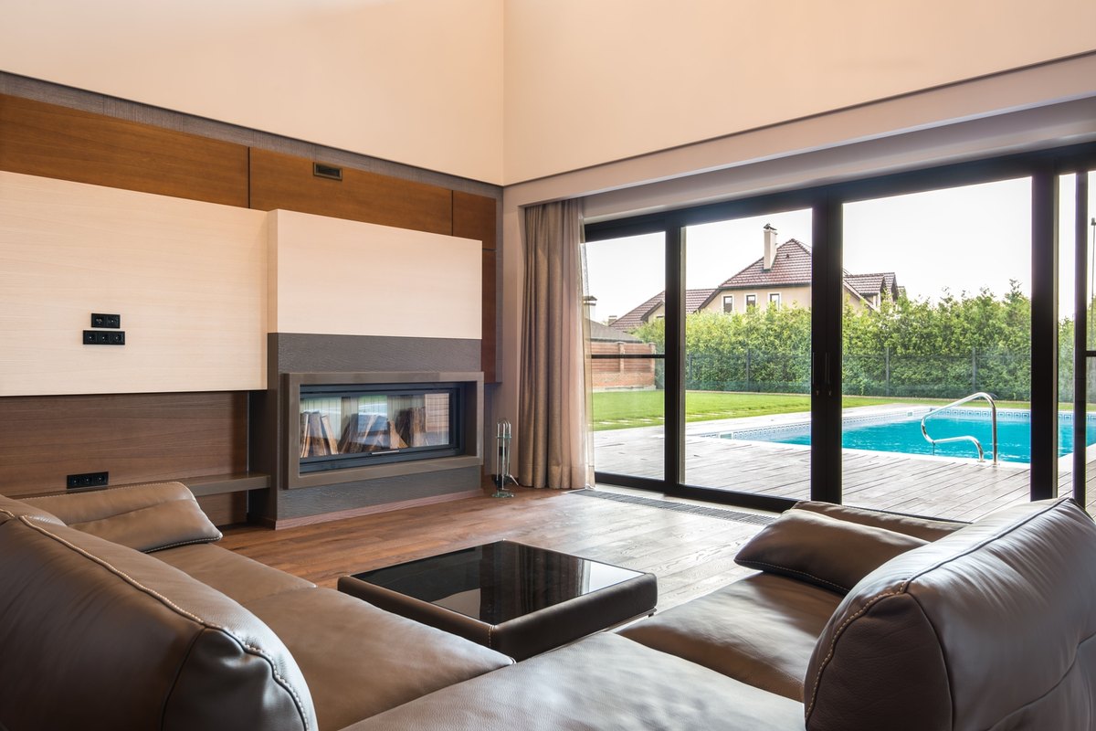 Black-framed sliding glass patio doors opening onto a wood deck and pool