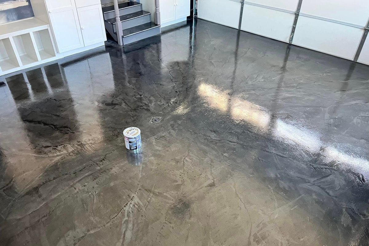 Gray and silver metallic epoxy floor with a floor drain, reflecting white shelves