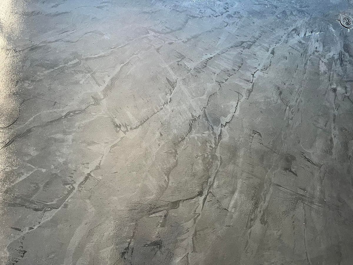 Close view of a dark gray metallic epoxy floor with pale marbled veining
