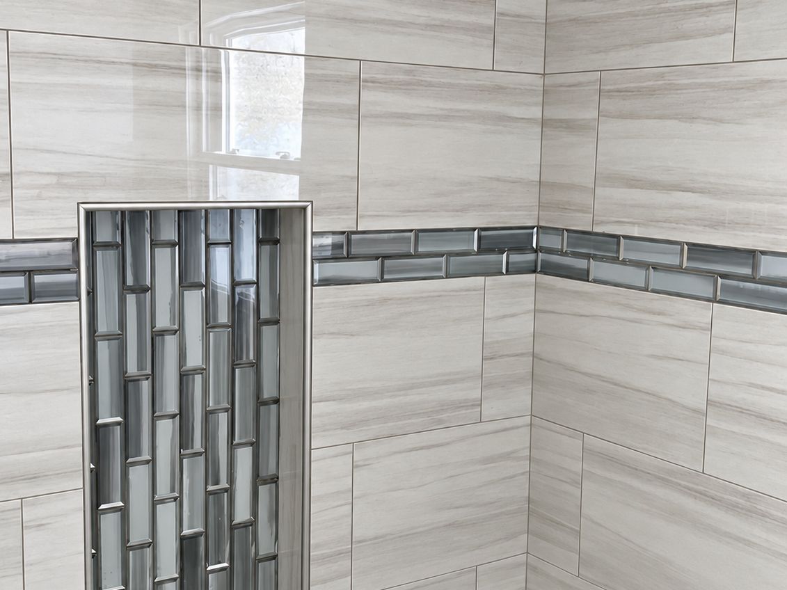 Bathroom tub surround: large white and gray wood-grain porcelain tiles in an offset pattern