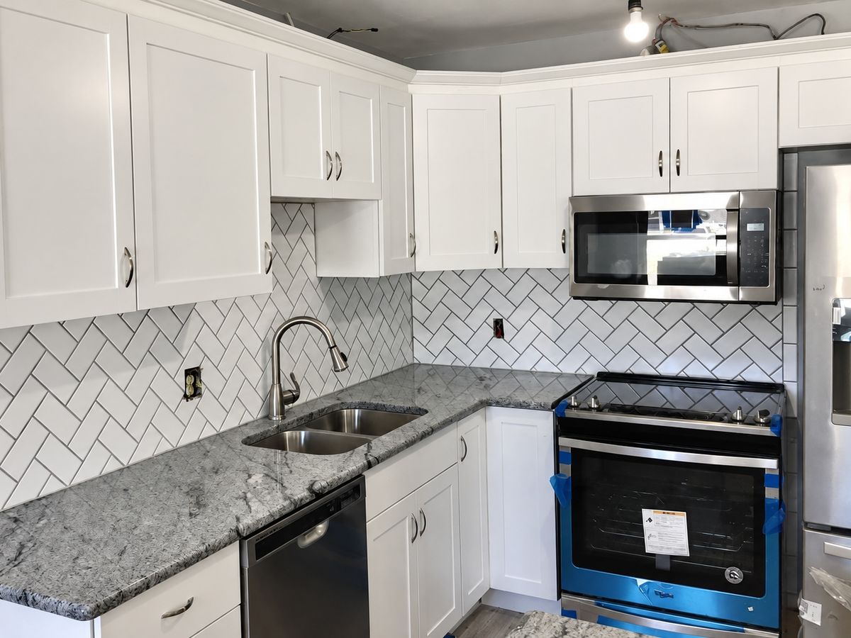 Finished kitchen with white shaker cabinets, a white herringbone subway tile backsplash
