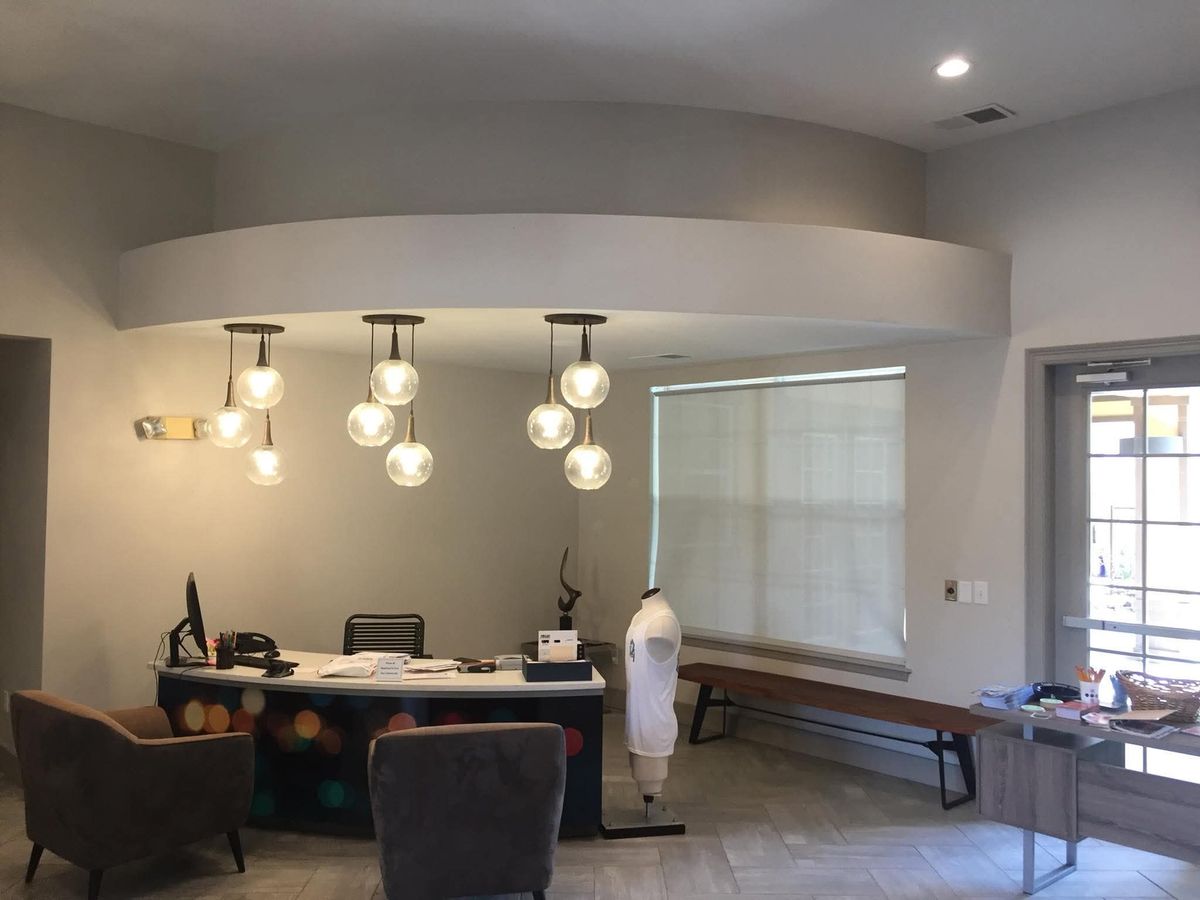 Front office with a curved soffit, three glass globe pendant lights