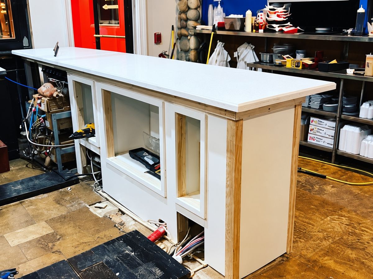 Restaurant service counter newly built: white panel faces with exposed pine corner trim